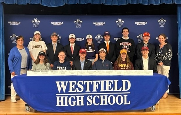 Photo of student athletes who signed National Letters of Intent to play in college. pictured with principal and athletic director