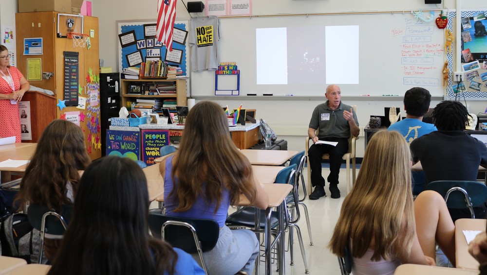 9/11 Survivor William Raff sits in front of students , sharing his impactful experience