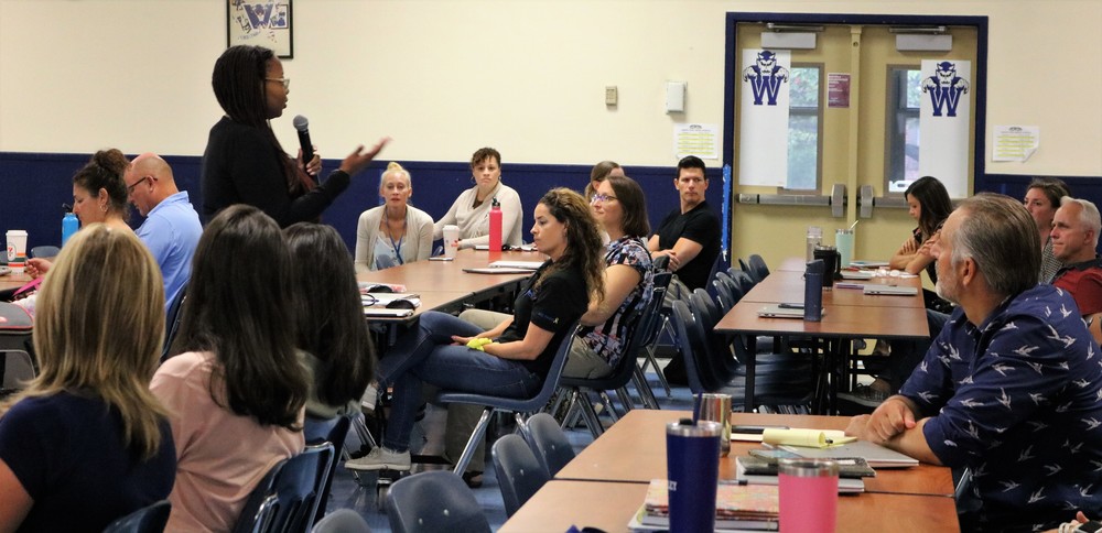 Facilitator from Imagine, A Center for Coping with Loss, speaks to seated staff members during  professional learning on grief-informed education on September 6.