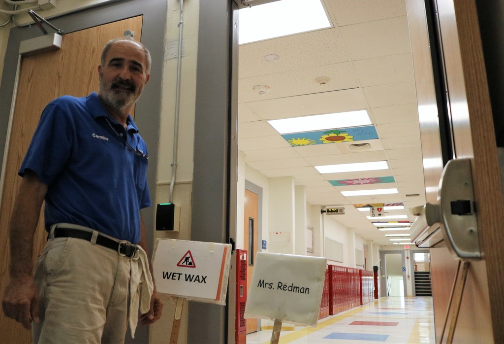 Lincoln head custodian smiles for the camera with "wet wax" sign