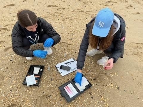 Two WHS students study on the beach