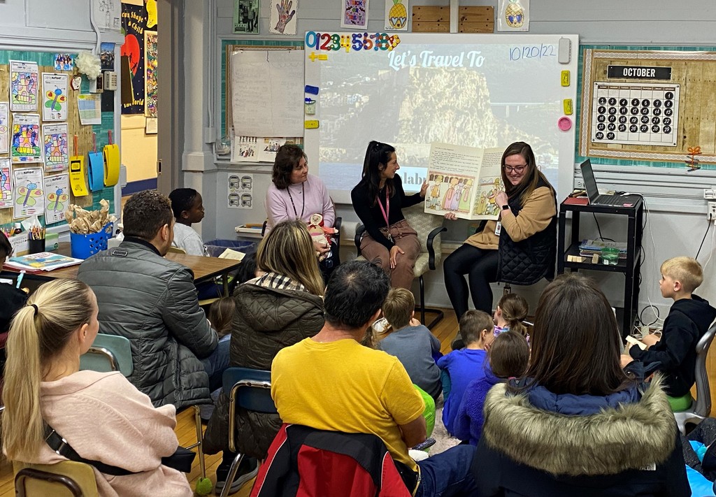 Three McKinley teachers read to a group of students and parents during Family Reading Night