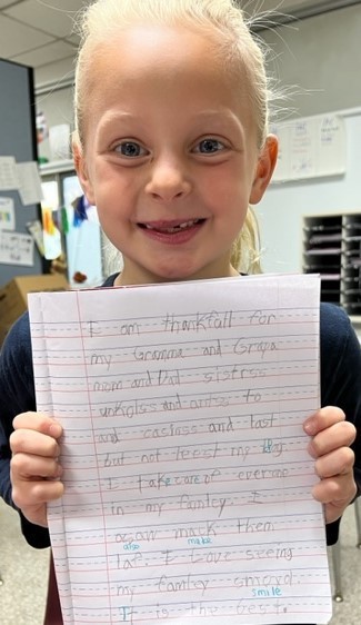 Washington student holds written assignment about what she is thankful for