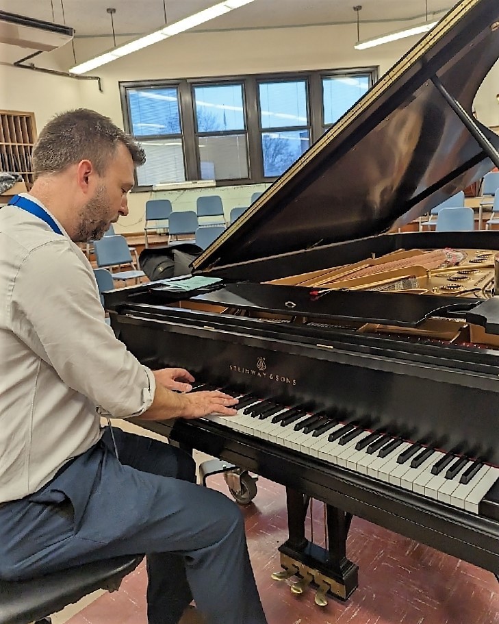 Choral Director John B plays newly refurbished Steinway piano