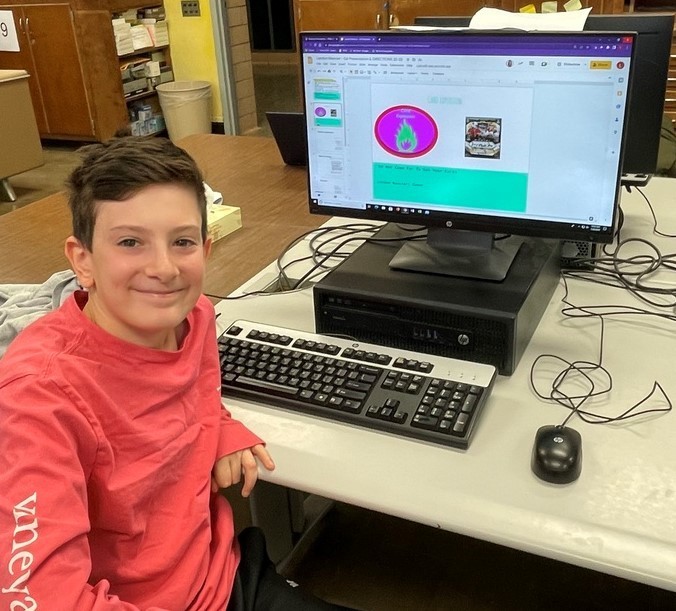 Edison 6th grader smiles for the camera while sitting at his computer