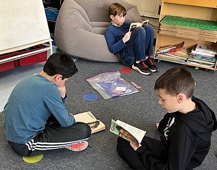 Three Jefferson 4th grade boys sit on floor and read