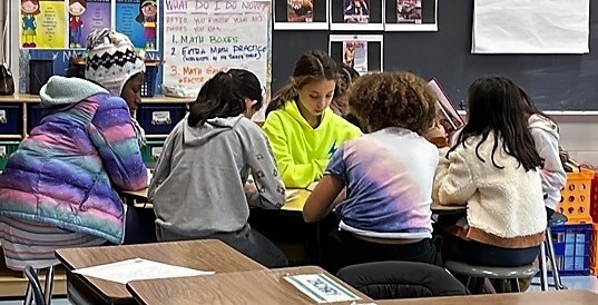 A group of 4th grade girls at Jefferson sit in a group to read