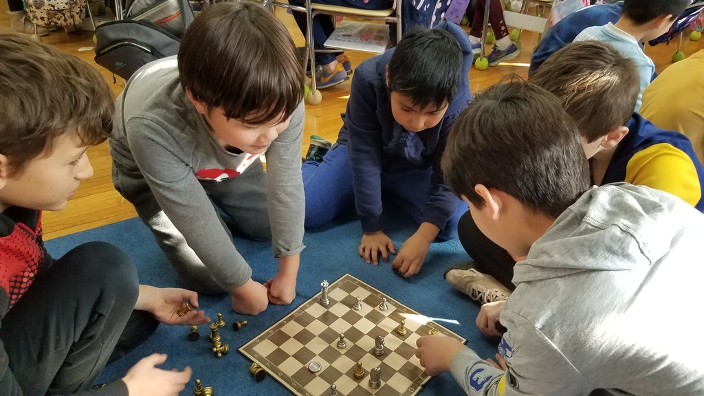 4th graders at McKinley surrounding a chess board on the floor