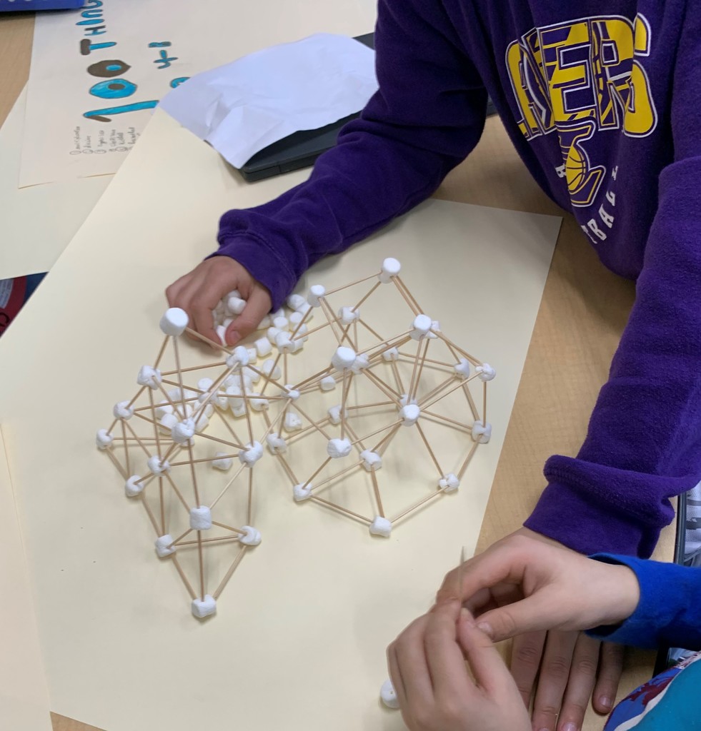 Close up of hands working on marshmallow  and toothpick structure