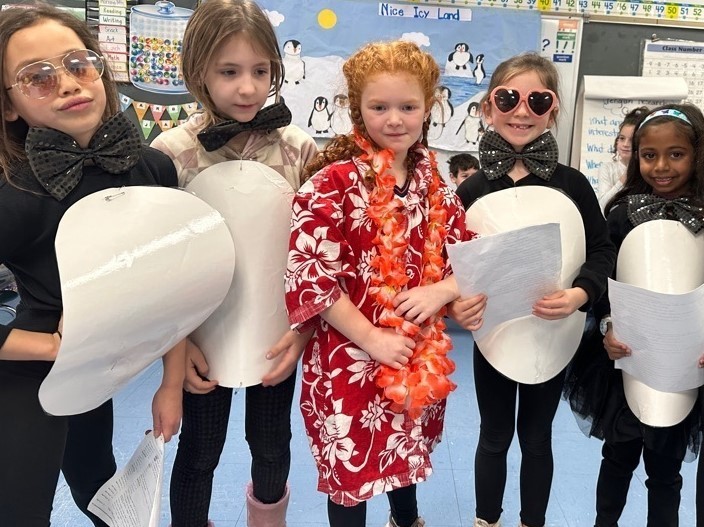 Five Wilson 1st graders pose for picture while wearing costumes during Readers Theater