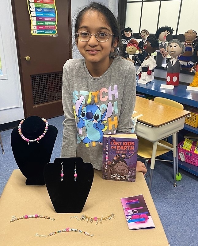 Franklin student smiles as she showcases jewelry