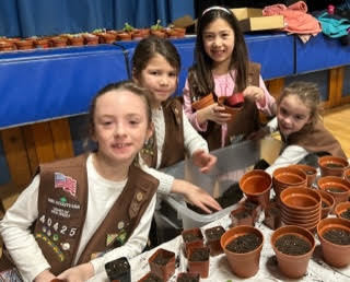 Washington Brownies pose for a picture with planting pots