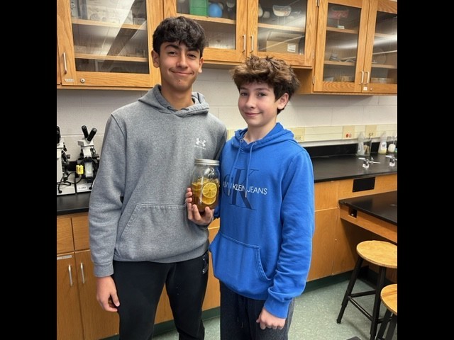 Two WHS students hold jar with fermented food as part of science unit