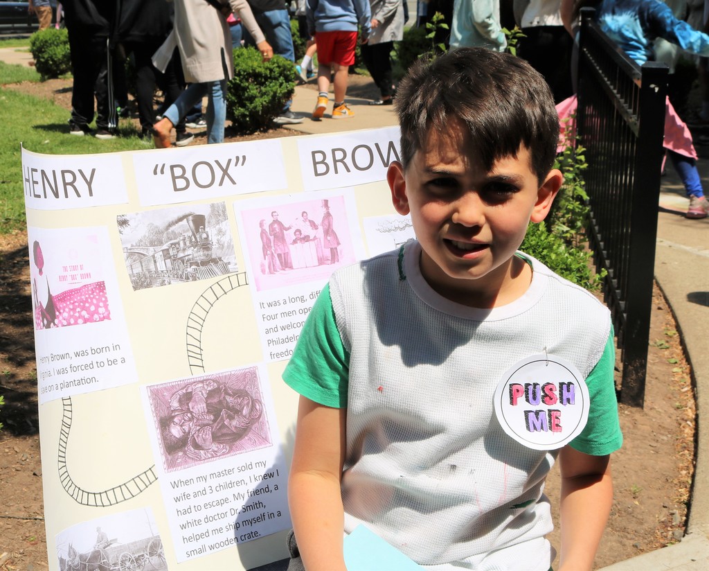 McKinley 4th grader smiles for the camera in front of his presentation on "Henry "Box" Brown