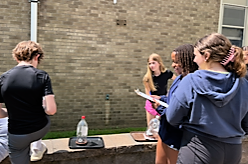 RIS students work together outside on science lab
