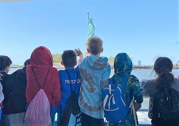 Franklin 3rd graders wave and look at Statue of Liberty as their boat passes by