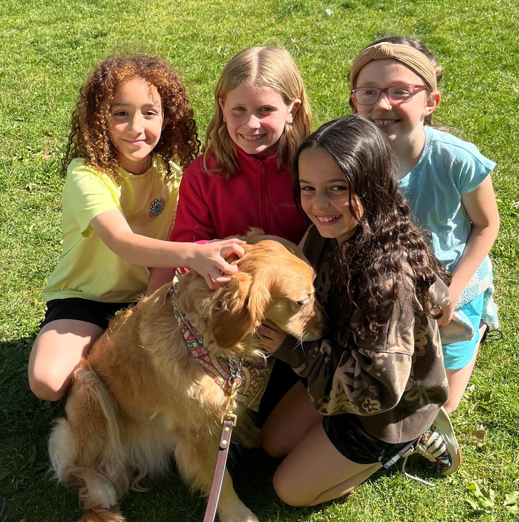 4 McKinley students smile for camera as they pet a therapy dog